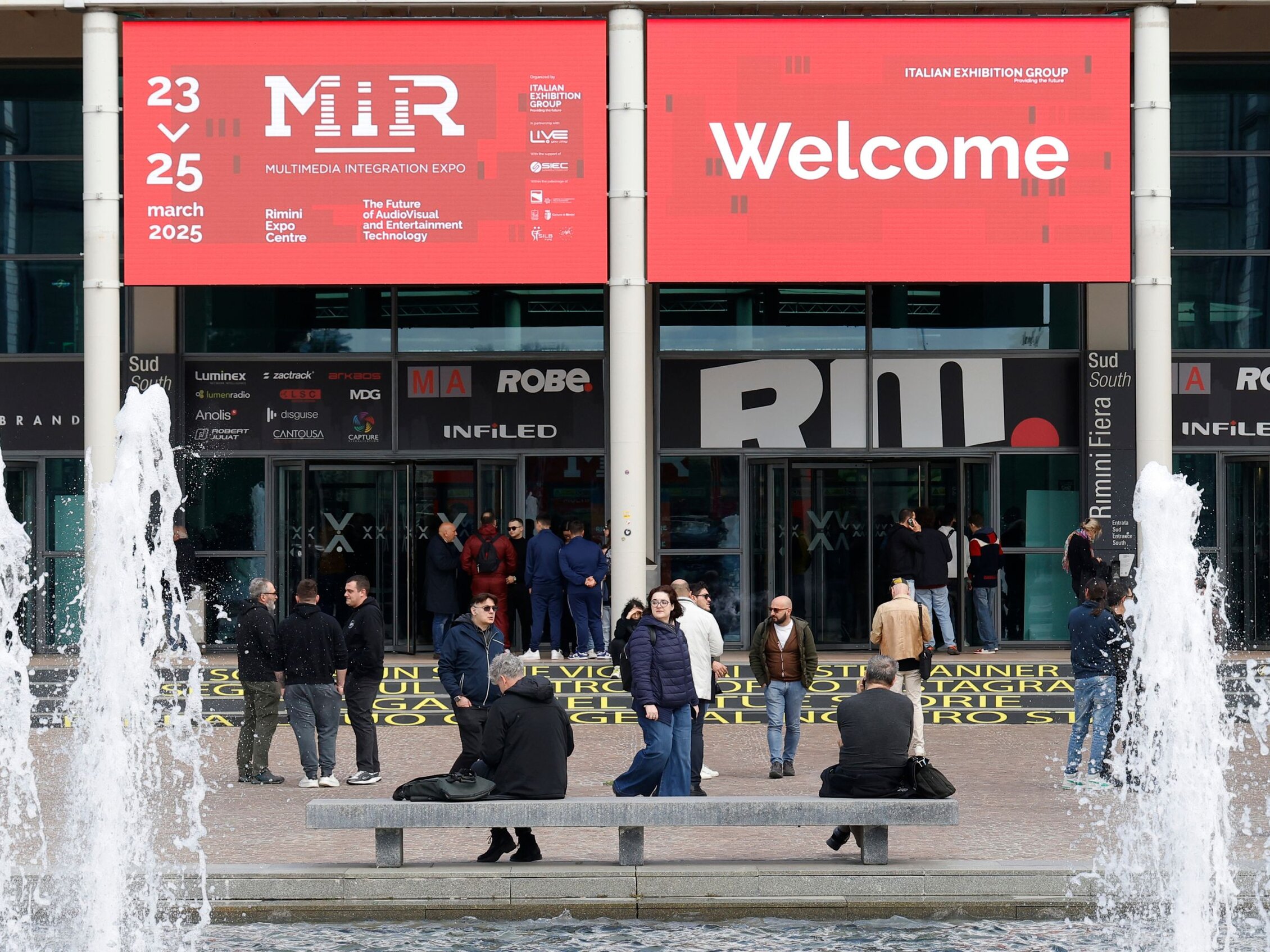 Ingresso MIR 2025 Visitatori all’ingresso del MIR 2025 alla Fiera di Rimini sotto l’insegna di benvenuto
