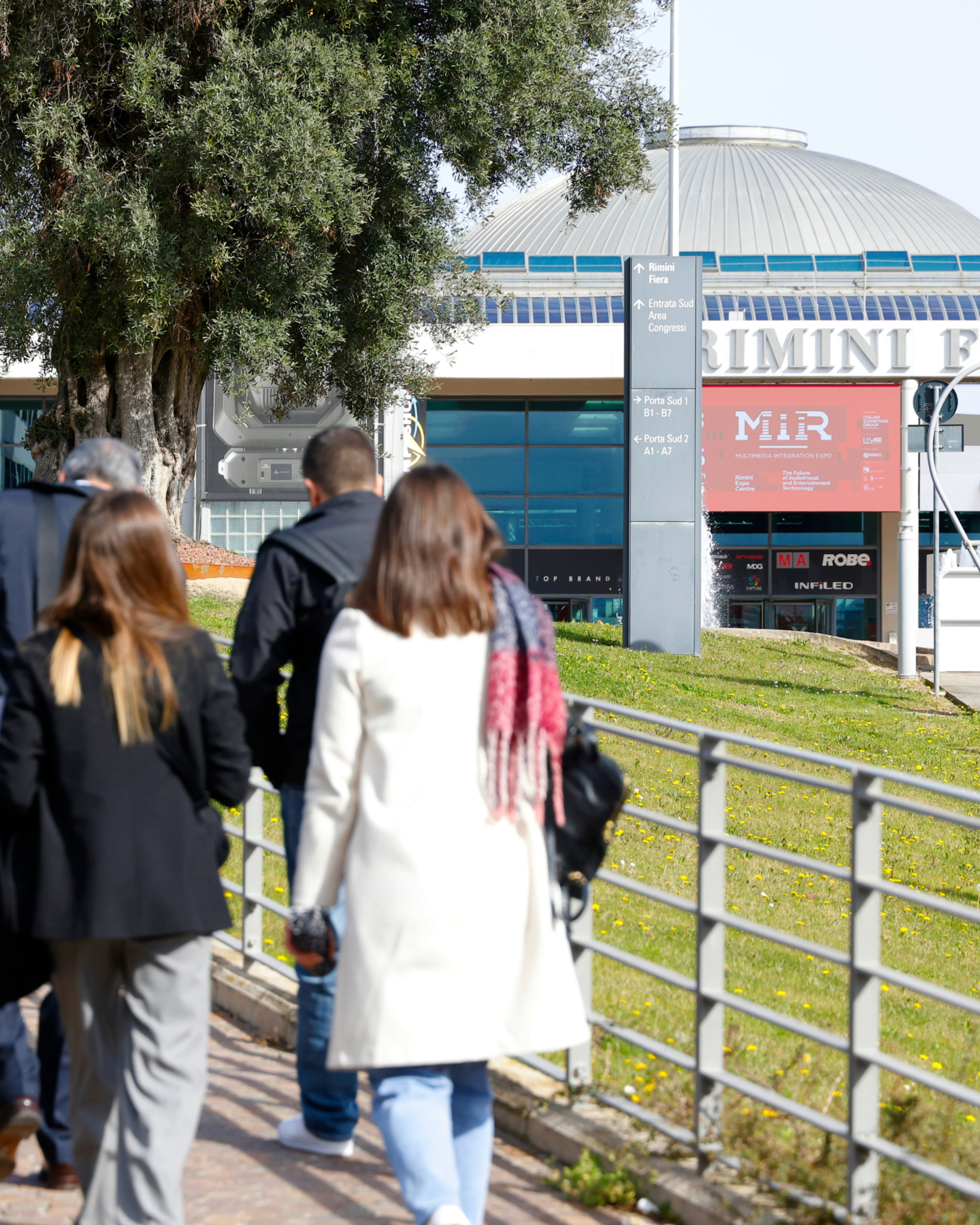 Visitatori in ingresso a piedi a MIR presso la fiera di Rimini, segnaletica e padiglione visibili Visitatori in ingresso a piedi a MIR presso la fiera di Rimini, segnaletica e padiglione visibili