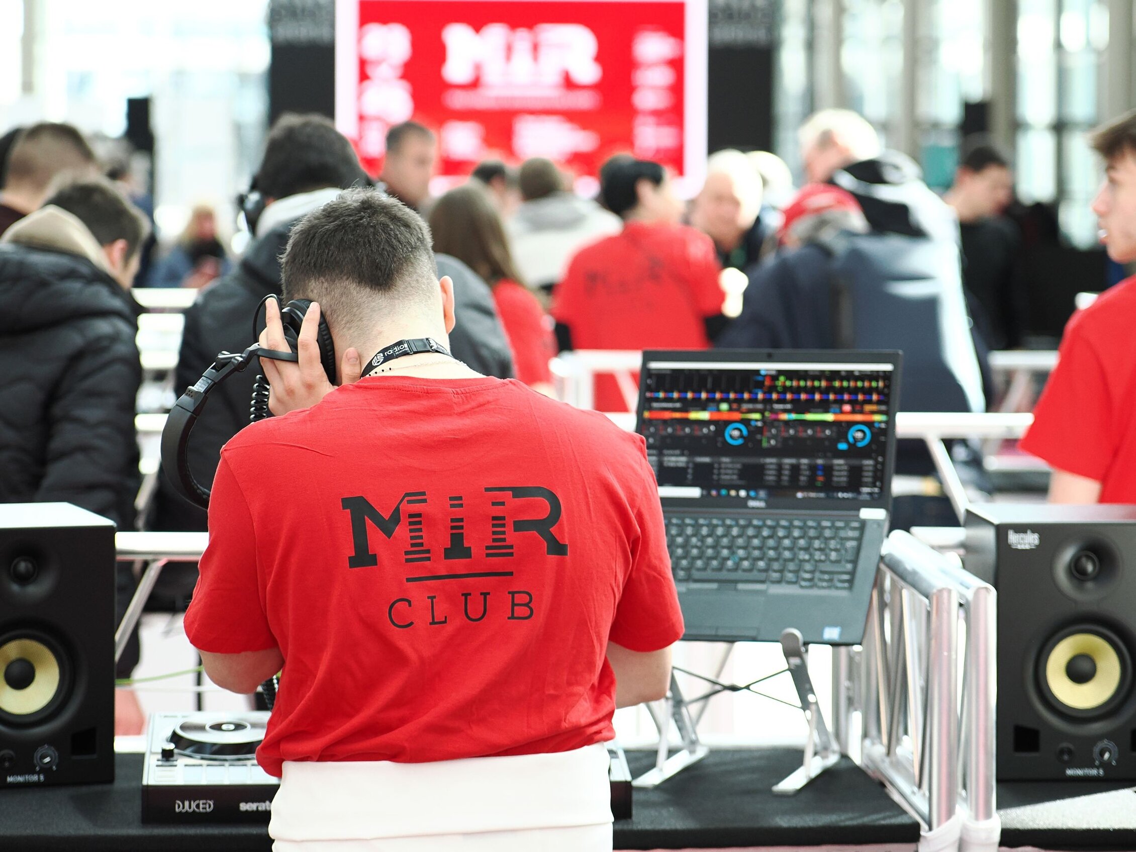 DJ con cuffie e consolle nella MIR Club Arena, evento dedicato a musica elettronica e tecnologie per DJ