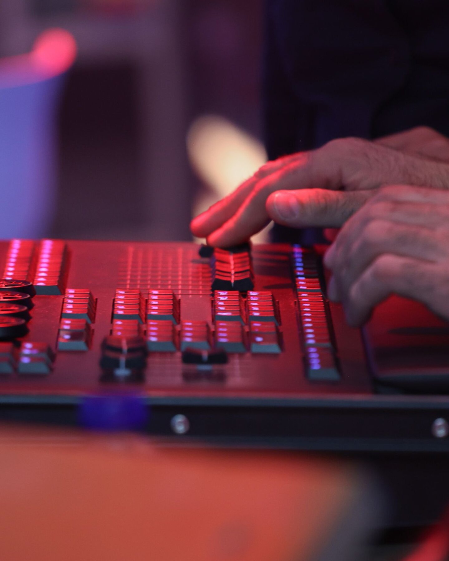Mani che regolano i controlli di una console luci professionale durante la gestione tecnica di uno spettacolo live Mani che regolano i controlli di una console luci professionale durante la gestione tecnica di uno spettacolo live