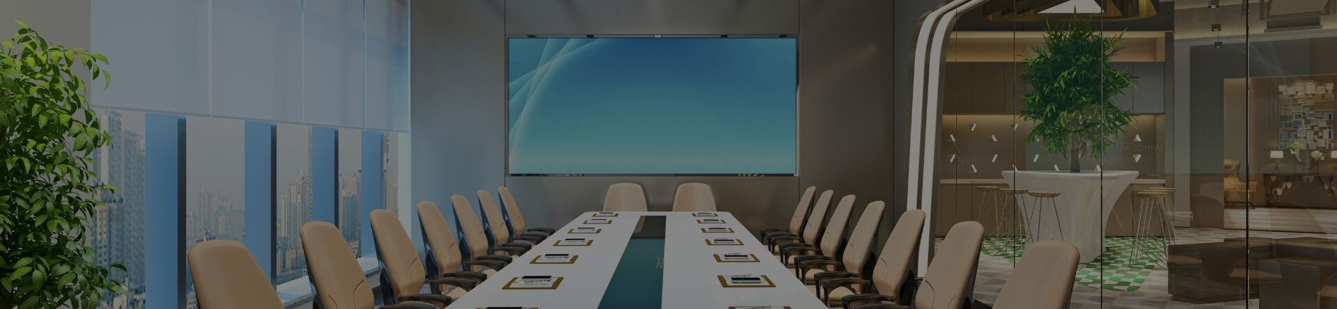 Sala riunioni aziendale con tavolo lungo e display centrale per presentazioni