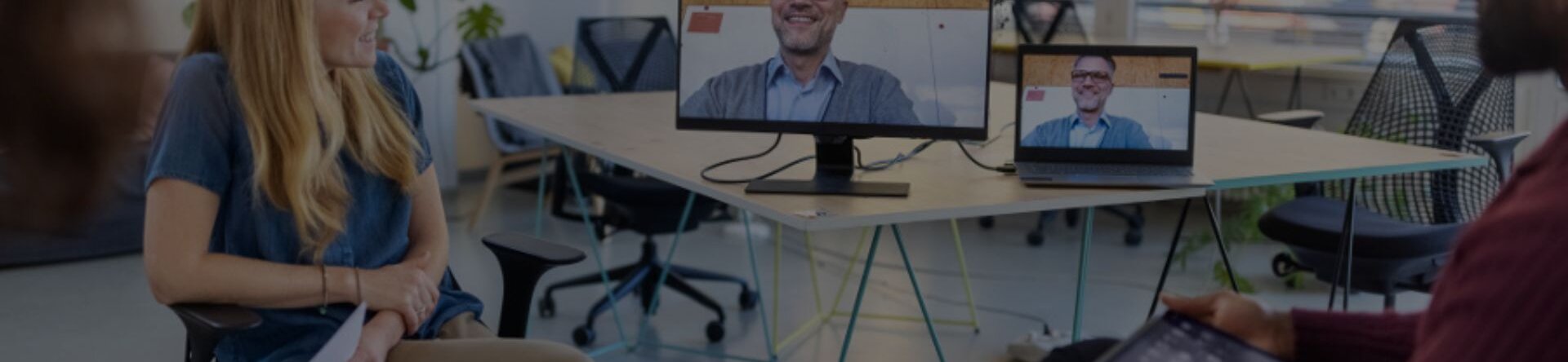 Team in ufficio open space con connessione video per lavoro agile