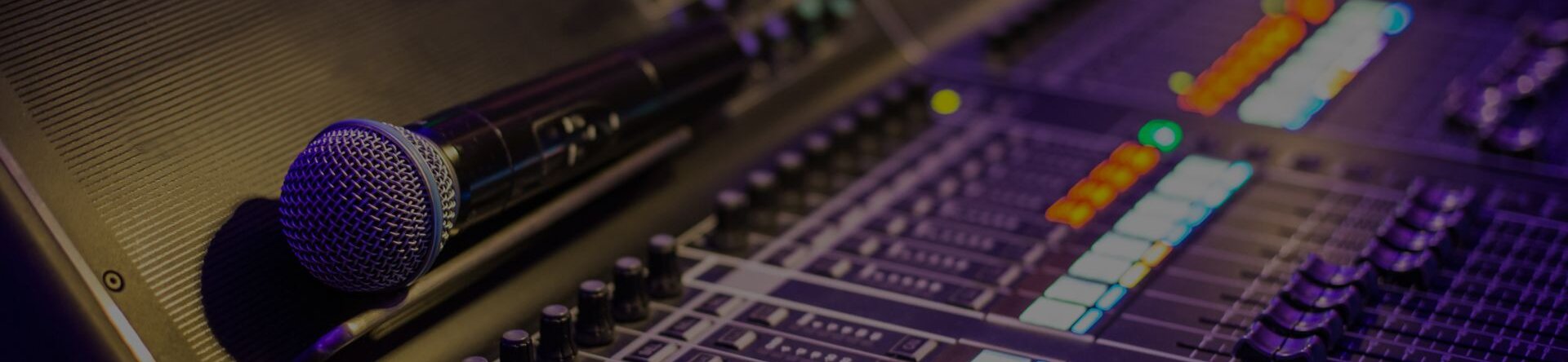Microfono wireless appoggiato su mixer audio con pulsanti illuminati